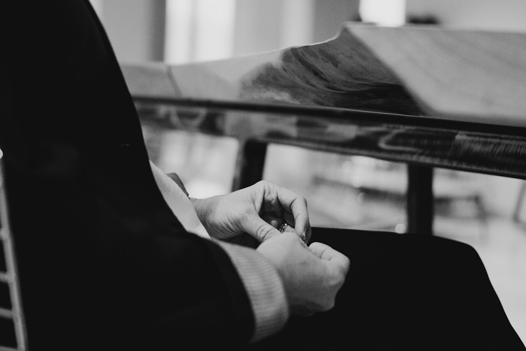 black and white photo of someone sitting down and picking their nails